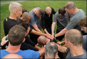 Steve Gfell, center, leads members of F3, a faith-based men's exercise group, in a prayer after their workout Wednesday, June 20, 2018, at Pacesetter Park in Sylvania.