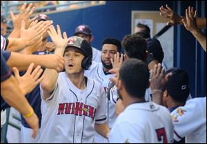 Jason Krizan celebrates scoring a run for the Mud Hens, who are in first place in the International League's West Division.