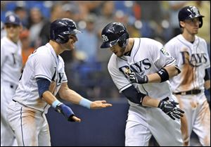 Tampa Bay Rays' Kevin Kiermaier, left, celebrates with C.J. Cron, center, after he scored with Matt Duffy, right, on Cron's three-run home run off Detroit Tigers' Jordan Zimmerman.