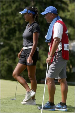 St. Ursula's graduate Lizzie Win consults with her caddie before putting on No. 9 in the first round of the LPGA Marathon Classic Thursday at Highland Meadows in Sylvania. 