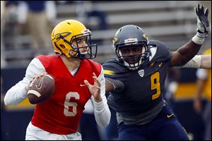Quarterback Mitchell Guadagni looks for an opening under pressure during the University of Toledo football spring scrimmage in April.