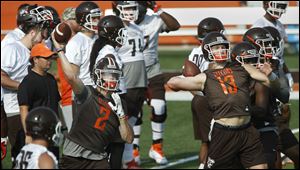 Quarterback Jarret Doege, left, and Grant Loy, throw passes during opening day of Bowling Green football practice at Doyt Perry Stadium on Friday