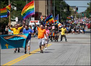 St. Lucas Lutheran Church members make their way down the street for the parade during the Toledo Pride Parade and Festival in downtown Toledo last August.