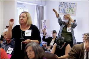 Cindy Matthews, right, stands in protest after members of the Lucas County Board of Elections voted to exclude two initiatives from the November ballot during a special meeting on Aug. 28 at the Early Voting Center in Toledo.