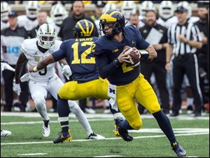 Michigan quarterback Shea Patterson (2) rolls out of the pocket looking to throw a pass against Western Michigan in Ann Arbor, Mich., on Saturday.